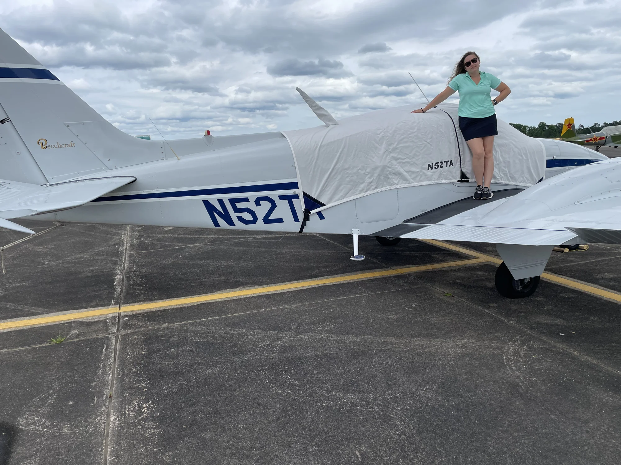 Ally on the wing of our Baron — the airplane we use to pick up new buys